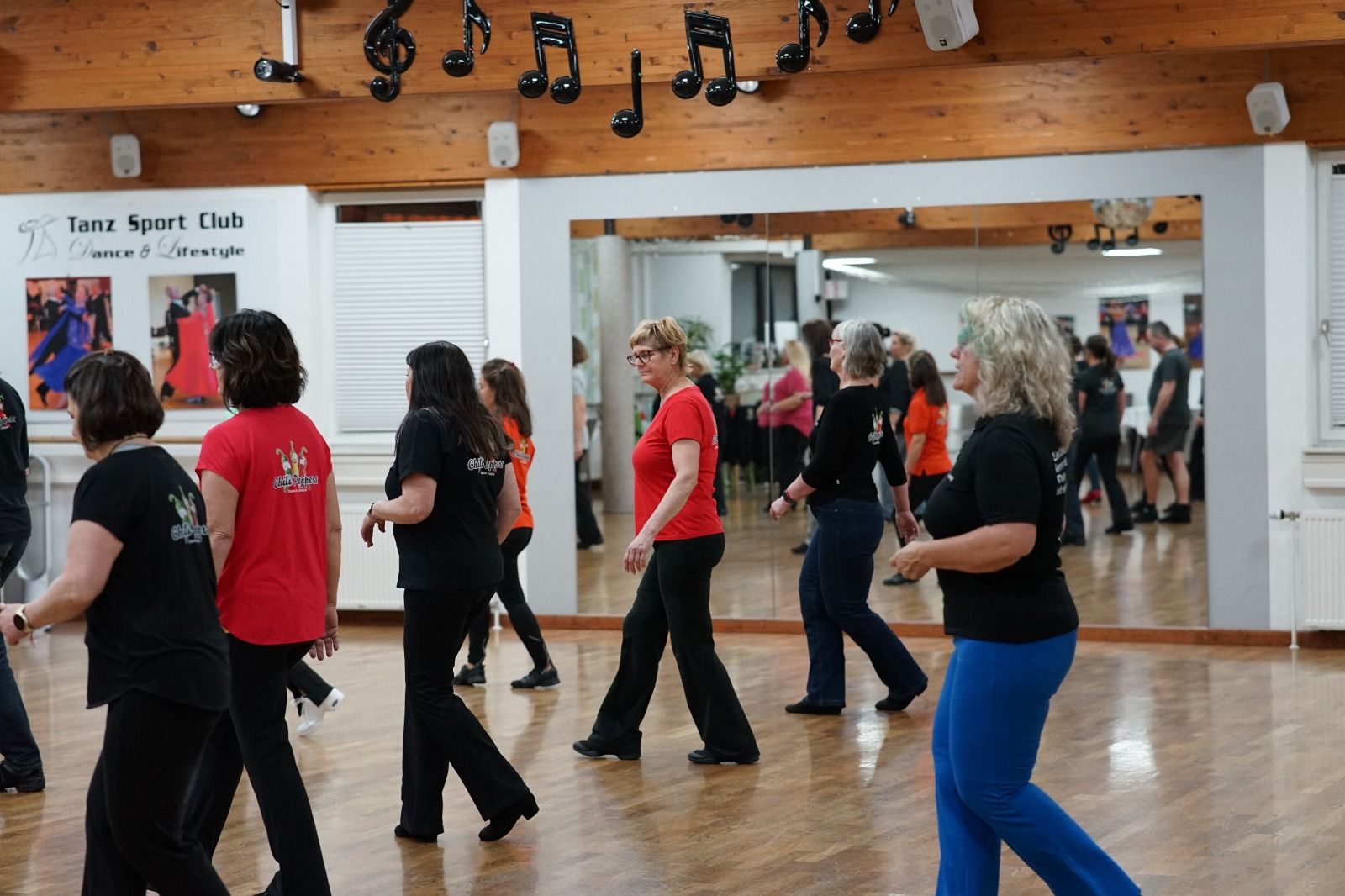 Line-Dance-Reihe im Trainingssaal, mehrere Tänzerinnen synchron im Schritt